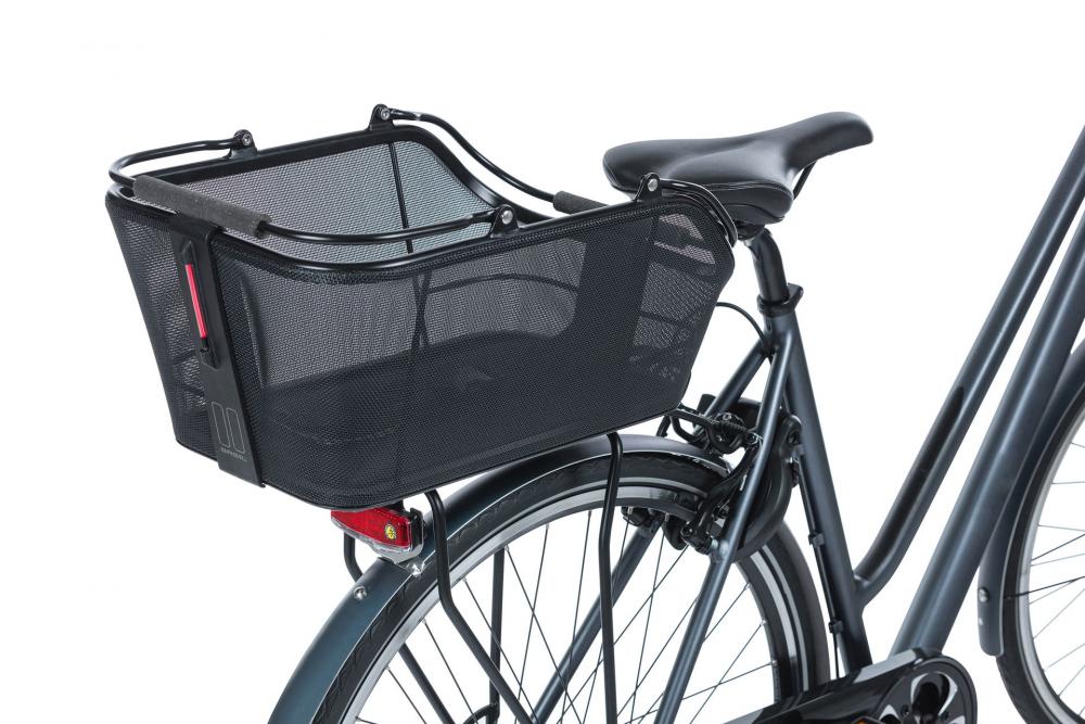 Detailaufnahme des schwarzen BASIL Cento Tech Fiber Nordlicht Hinterradkorbs (21L) mit MIK 2.0 und LED-Rücklicht am Fahrrad.