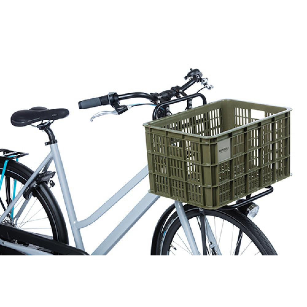 Moosgrüne Basil Crate L 40L Fahrradkiste aus recyceltem Kunststoff auf dem Frontgepäckträger eines grauen Fahrrads.