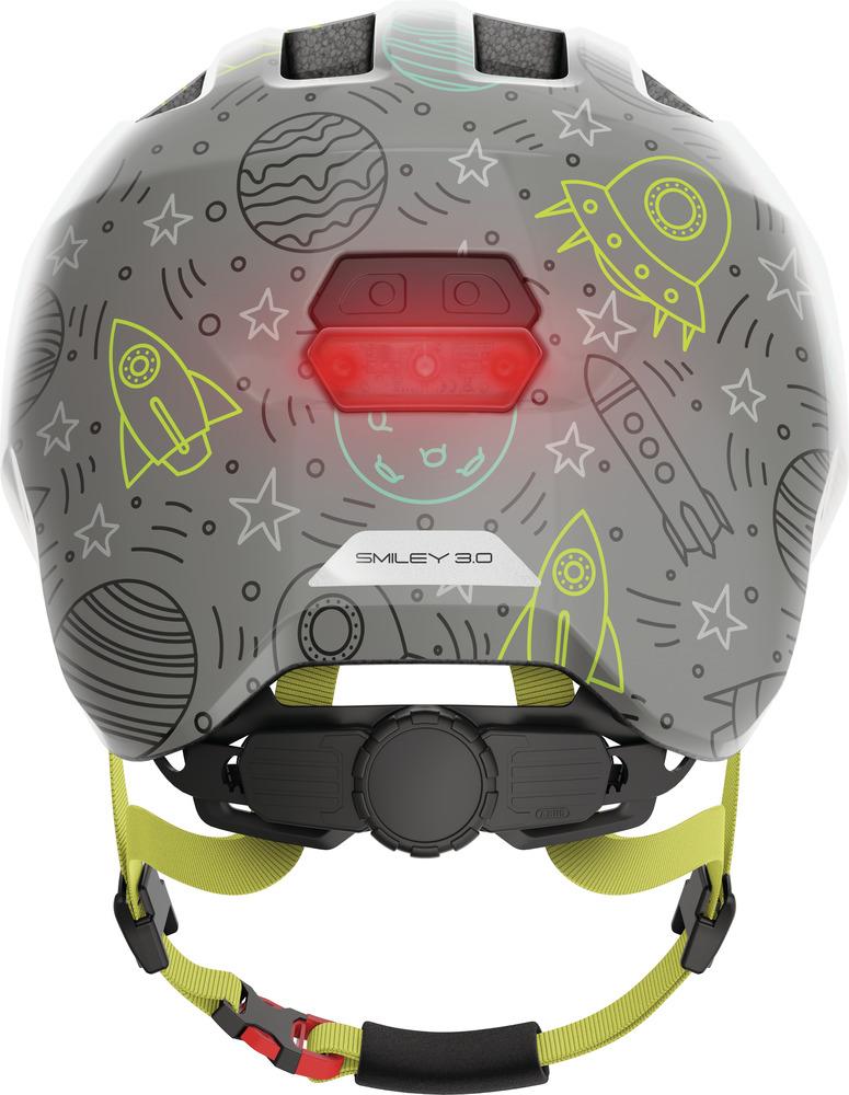 Abus Kinderhelm Smiley 3.0 LED grau Weltall-Design mit Raketen, Planeten, Sternen und leuchtendem Rücklicht.