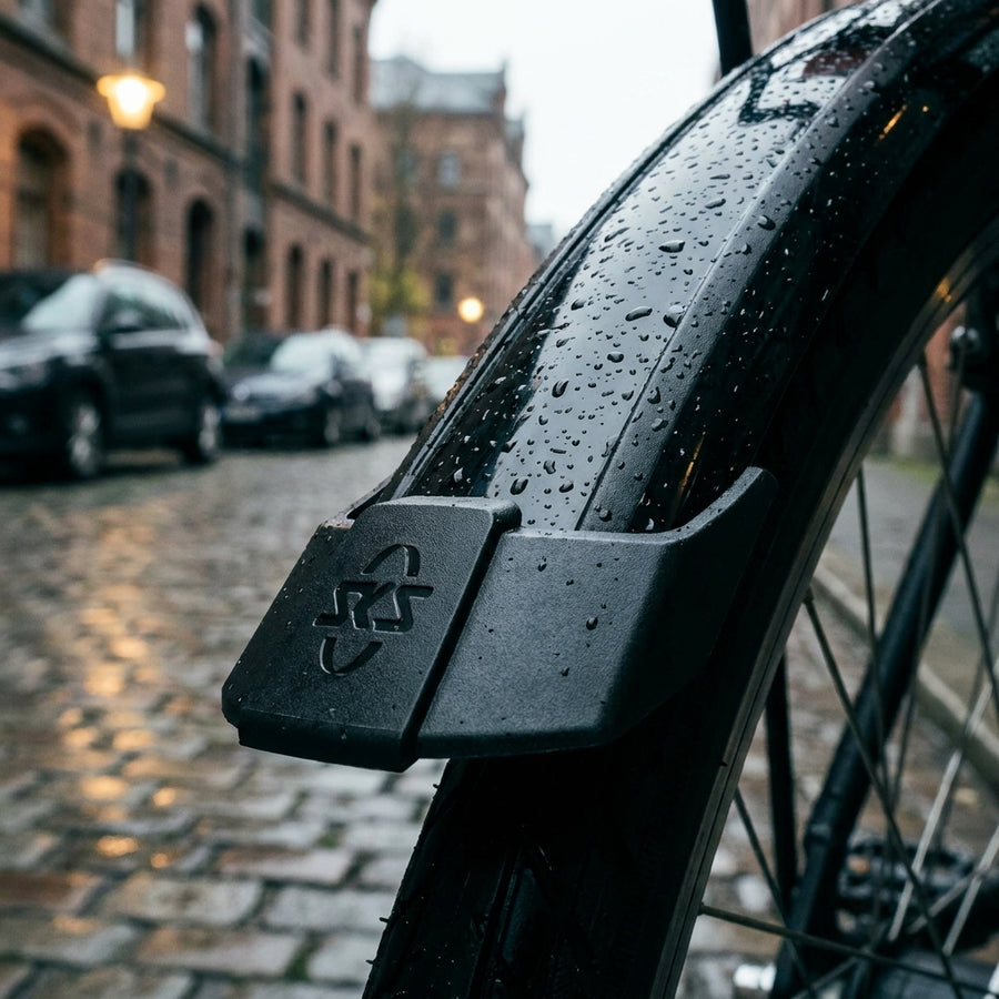 SKS Bluemels Style Kantenschoner am Fahrradschutzblech mit Regentropfen auf nasser Kopfsteinpflasterstraße.