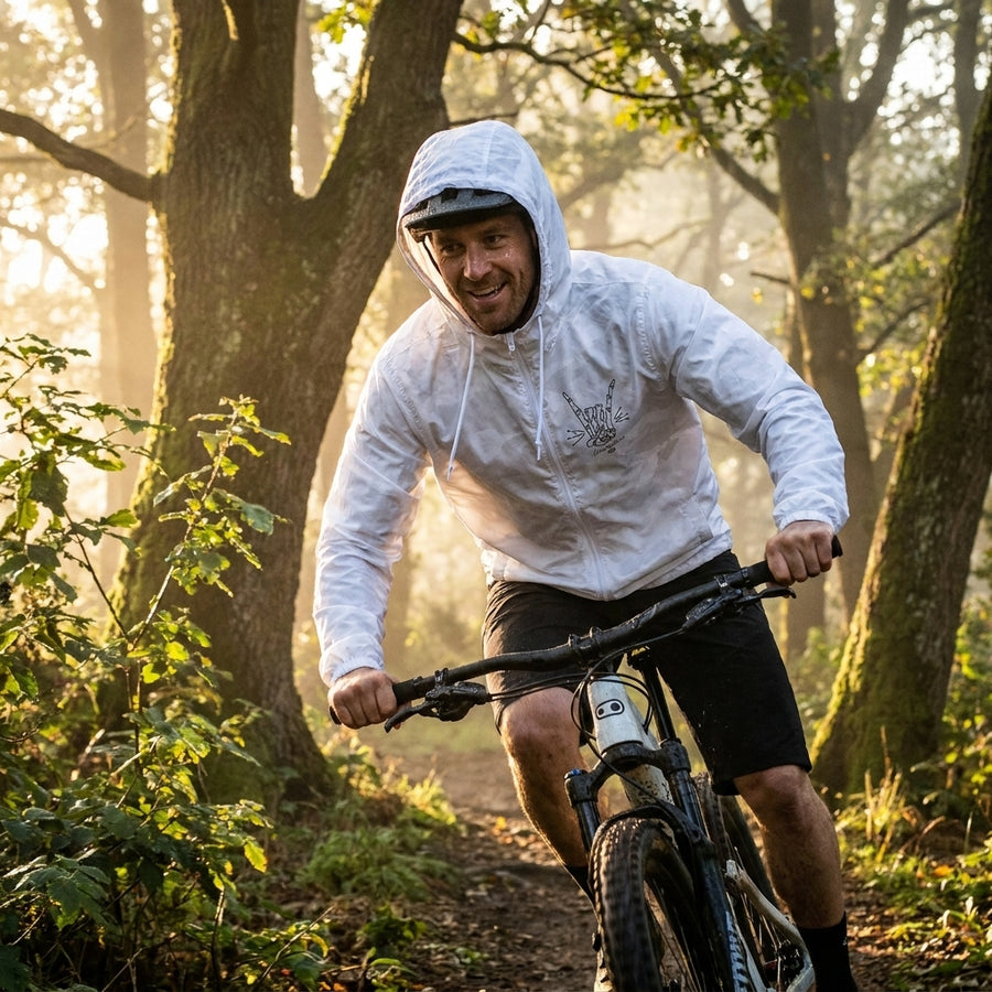 Crankbrothers Herren Windbreaker Range Rock & Roll weiß, Mann auf Mountainbike im Wald.