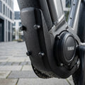 Yamaha Abdeckung Rahmenschloss für Mittelmotorsystem X942+X943 2015 am E-Bike, schwarz, mit Wassertropfen.