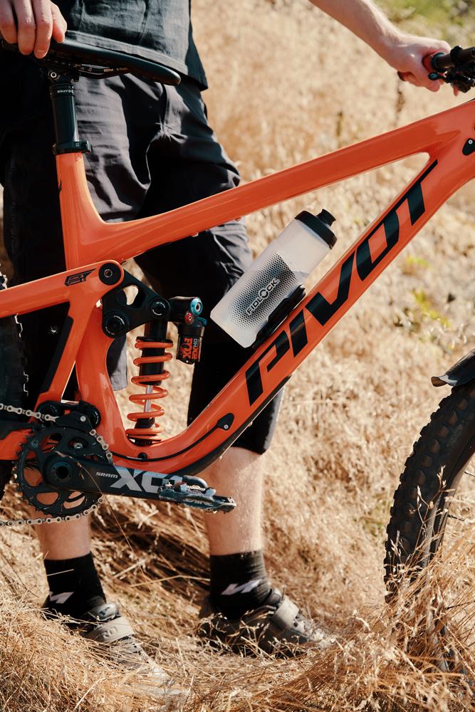 Fidlock Twist Bottle 600ml magnetisch am orangefarbenen Mountainbike befestigt.