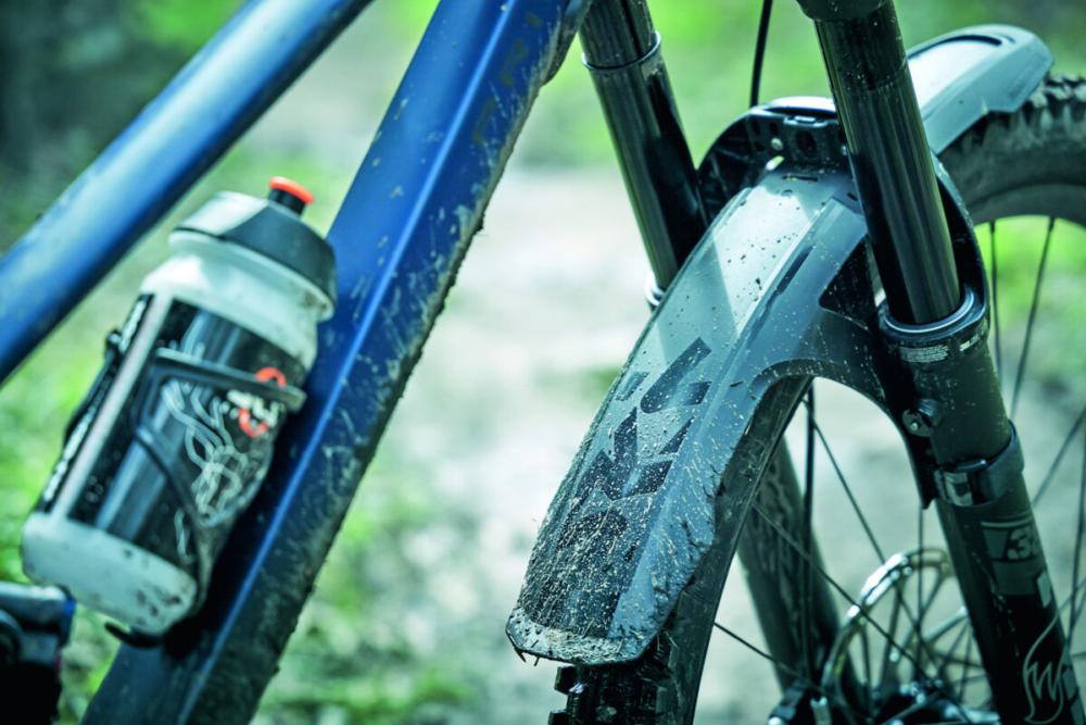 Schwarzes SKS Mudrocker Front Schutzblech an einem schlammigen Mountainbike für optimalen Spritzschutz, montiert.