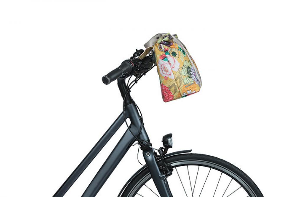 Honiggelbe Basil Bloom Field Schultertasche mit Blumenmuster am Fahrradlenker.