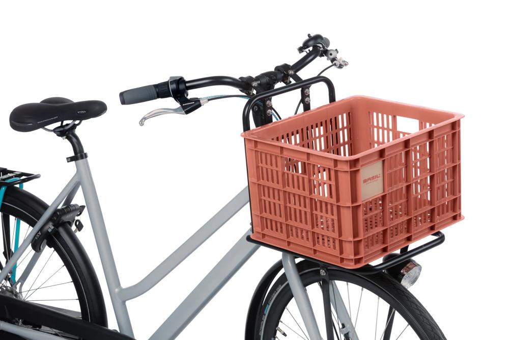 Graues Fahrrad mit roter Basil Crate M Fahrradkiste aus recyceltem Kunststoff am Frontgepäckträger.