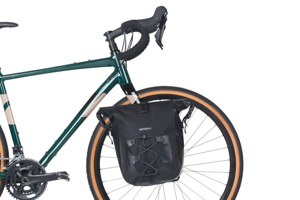 Basil Einzelpacktasche Navigator Waterproof M, schwarz, am Vorderrad eines grünen Fahrrads.