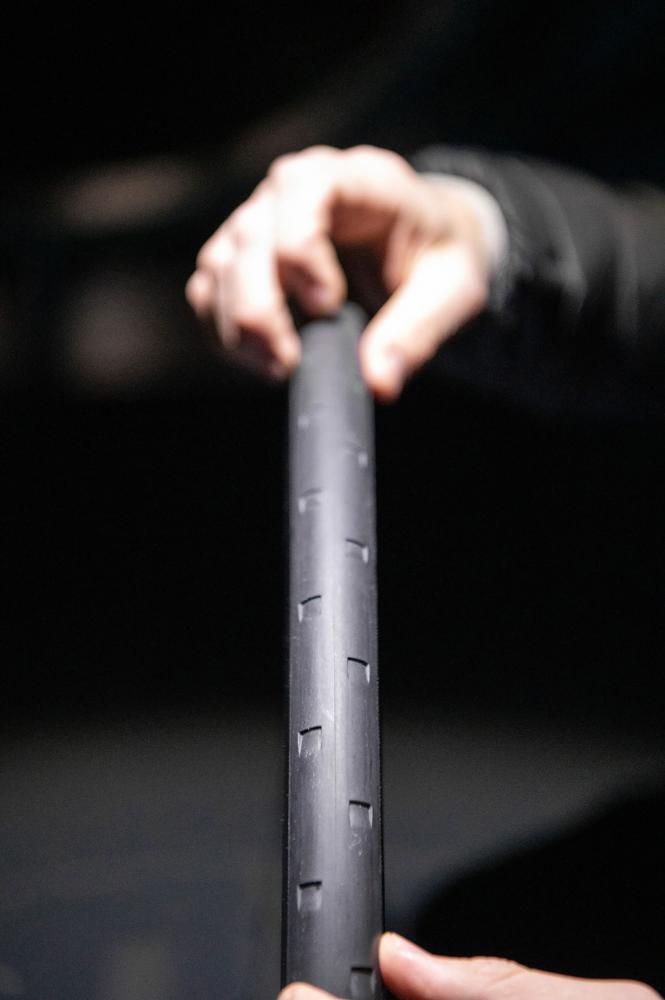 Hand hält schwarzes DT Swiss ERC 1100 Dicut Disc Carbon-Endurance-Laufrad mit Aero-Reifenprofil.