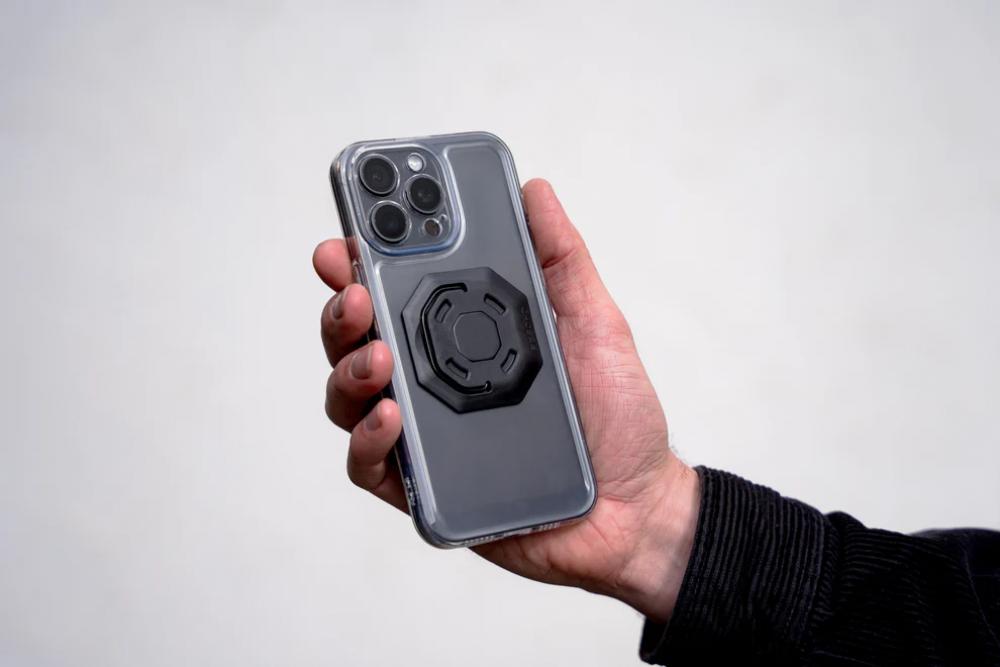 FESCHD Smartphonehalter Bike Bundle: Schwarze Adapterplatte am Smartphone, von Hand gehalten.
