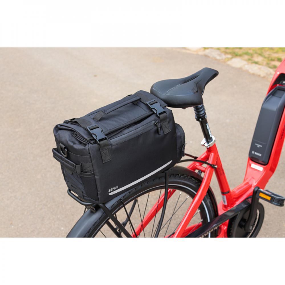 Schwarze Zefal Z Travel 60 Fahrradtasche 20L am roten E-Bike. Mit Tragegriff und Reflektoren.