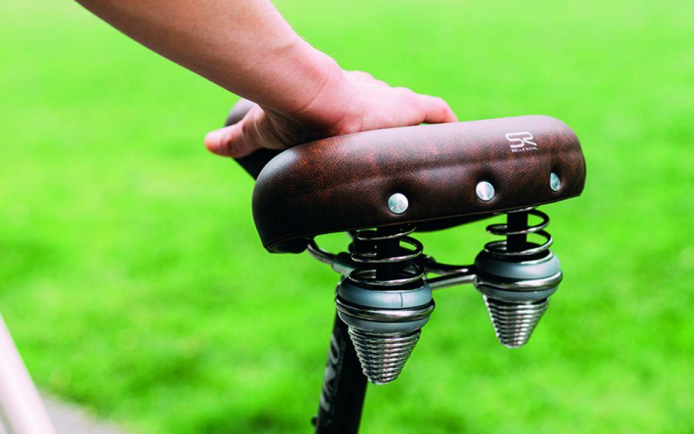 Selle Royal Drifter Fahrradsattel, braun, mit Doppelfedern und Vintage-Design. Hand auf dem Sattel.