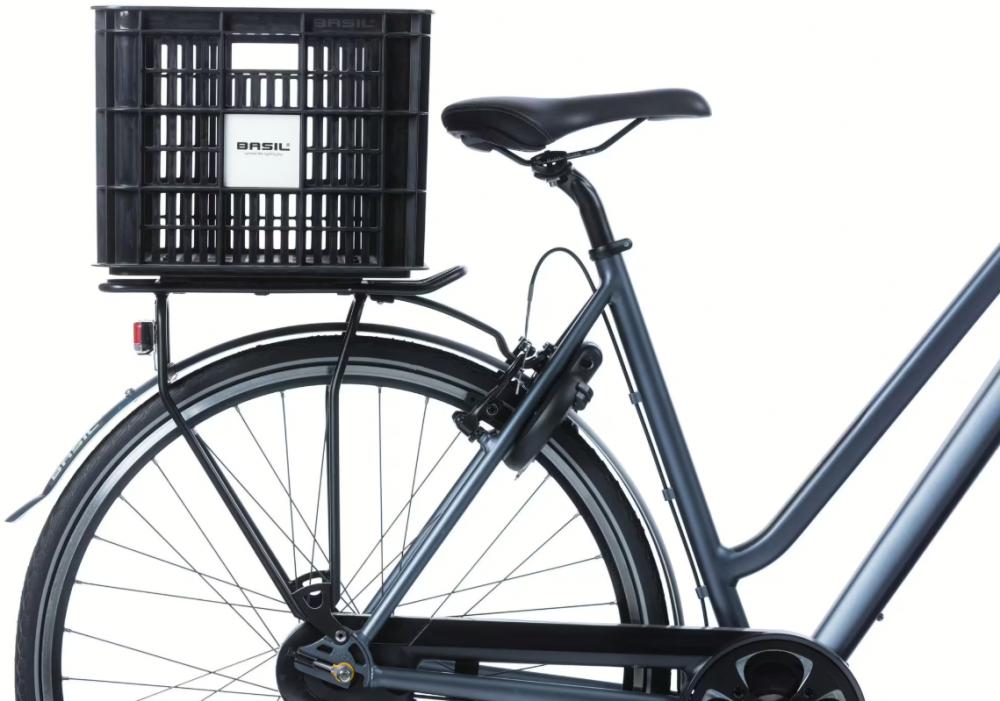 Dunkelgraues Fahrrad mit schwarzer Basil MIK 2.0 Fahrradkiste auf dem hinteren Gepäckträger.