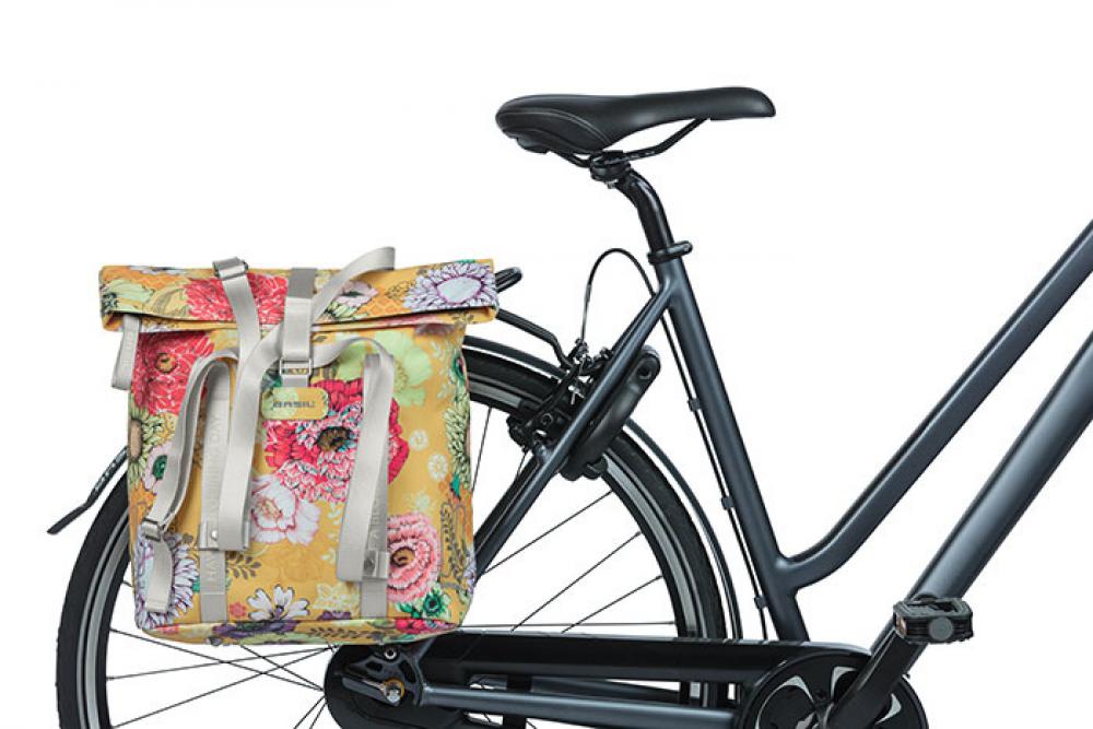 Basil Schultertasche Bloom Field Shopper honey yellow mit Blumenmuster am Fahrradgepäckträger befestigt.