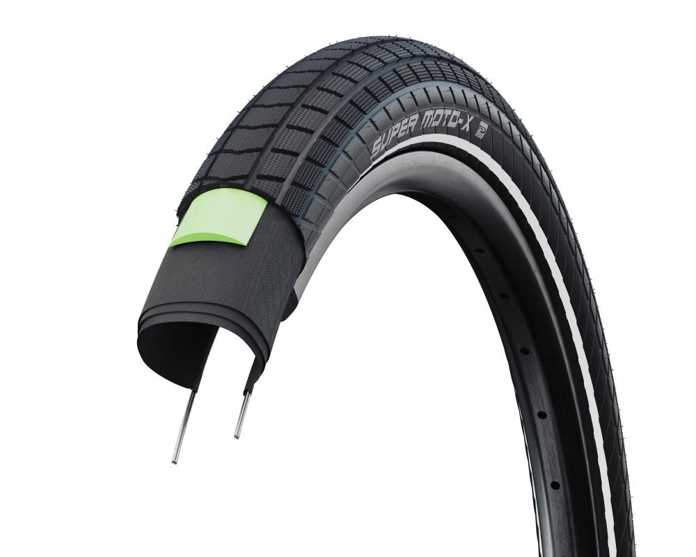 Schwalbe Super Moto-X 20x2.40 E-Bike Reifen Querschnitt mit grünem GreenGuard Pannenschutz und Reflexstreifen.