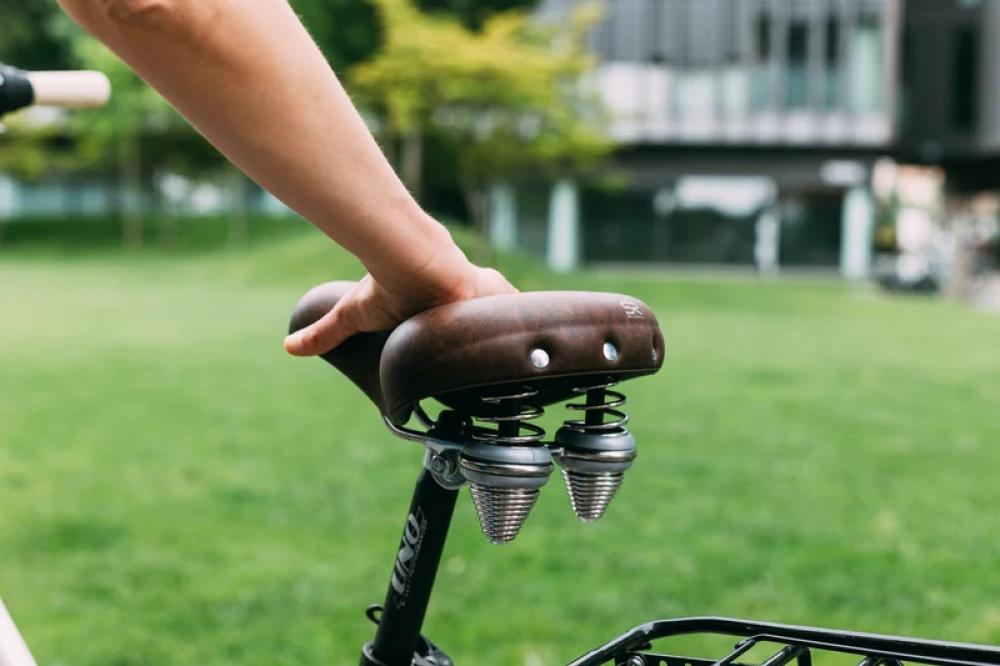 Hand auf braunem Selle Royal Drifter Fahrradsattel mit Doppelfedern, Royalgel und Vintage-Design für Citybikes.