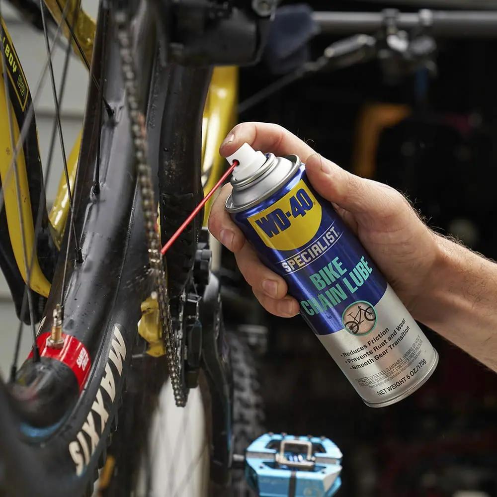 WD-40 Kettenspray 250 ml zur Allwetter-Schmierung und für Korrosionsschutz wird auf eine Fahrradkette aufgetragen.